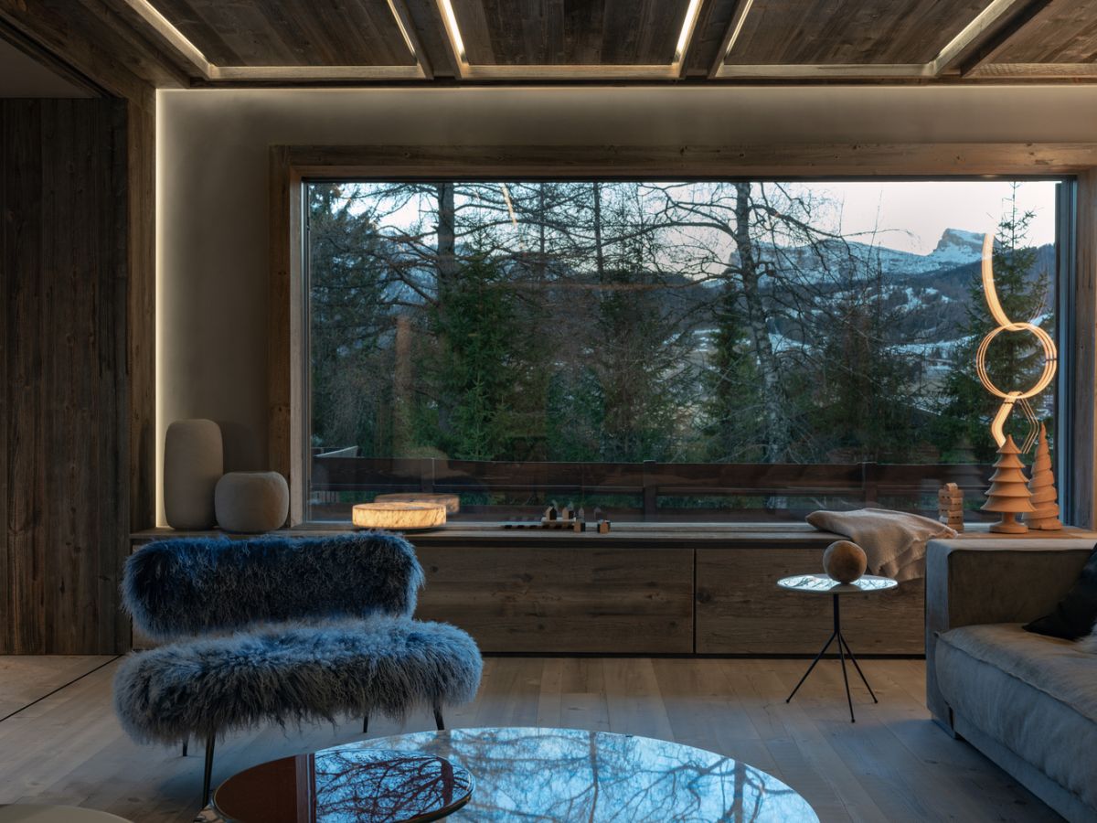 Large windows are framed by cozy seating nooks and benches that complete the decor in a charming manner