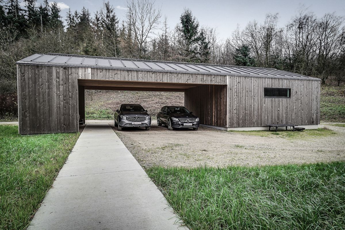 The carport acts as a privacy shield, a barrier between the house and the trail