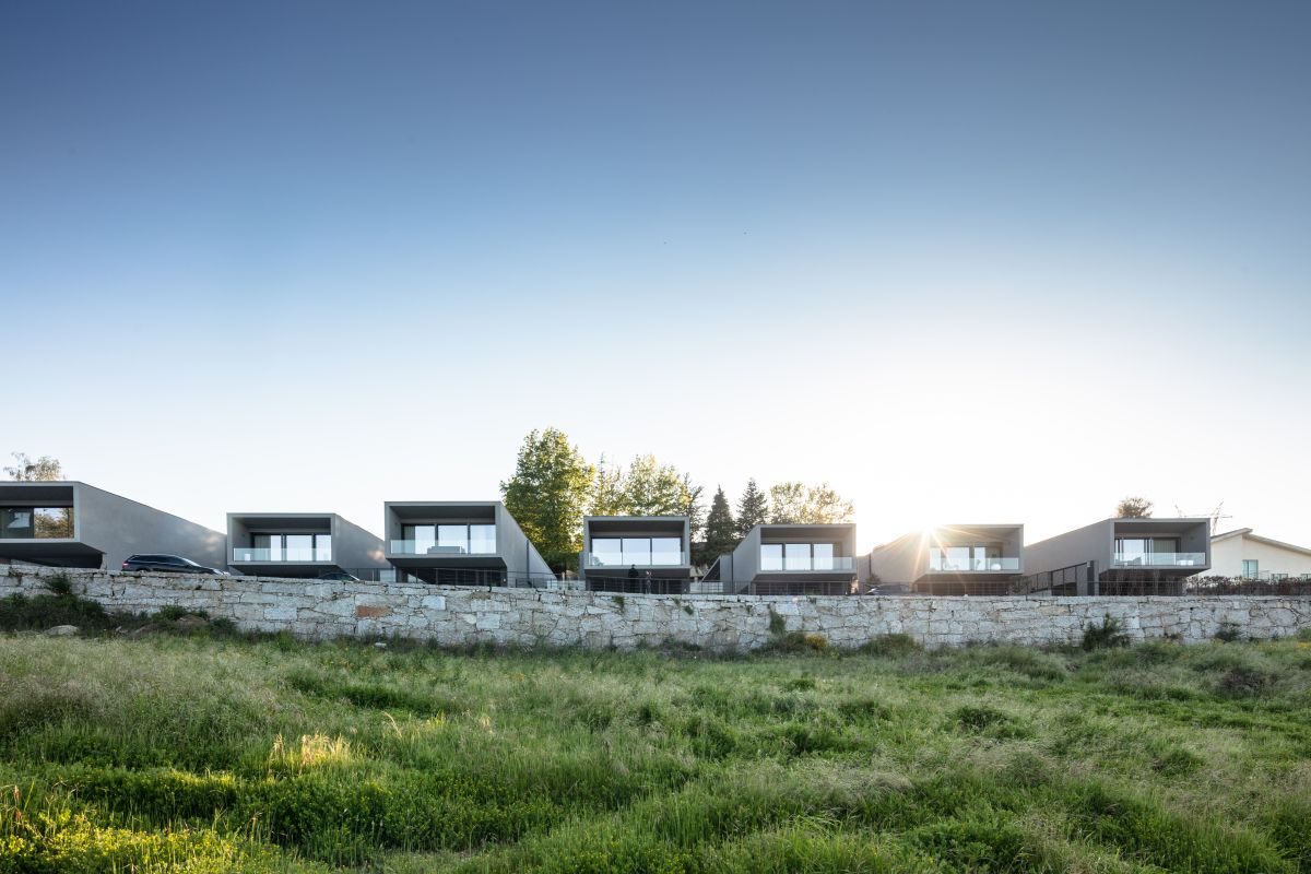 All seven houses are lined up, oriented towards the view and parallel to each other