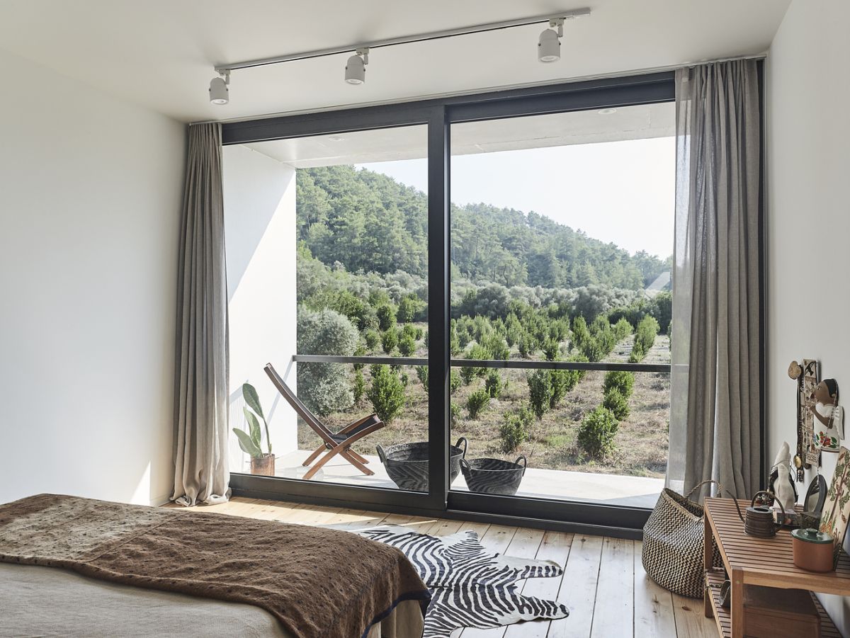 The bedroom has its own tiny balcony and full-height windows that bring the outdoors in