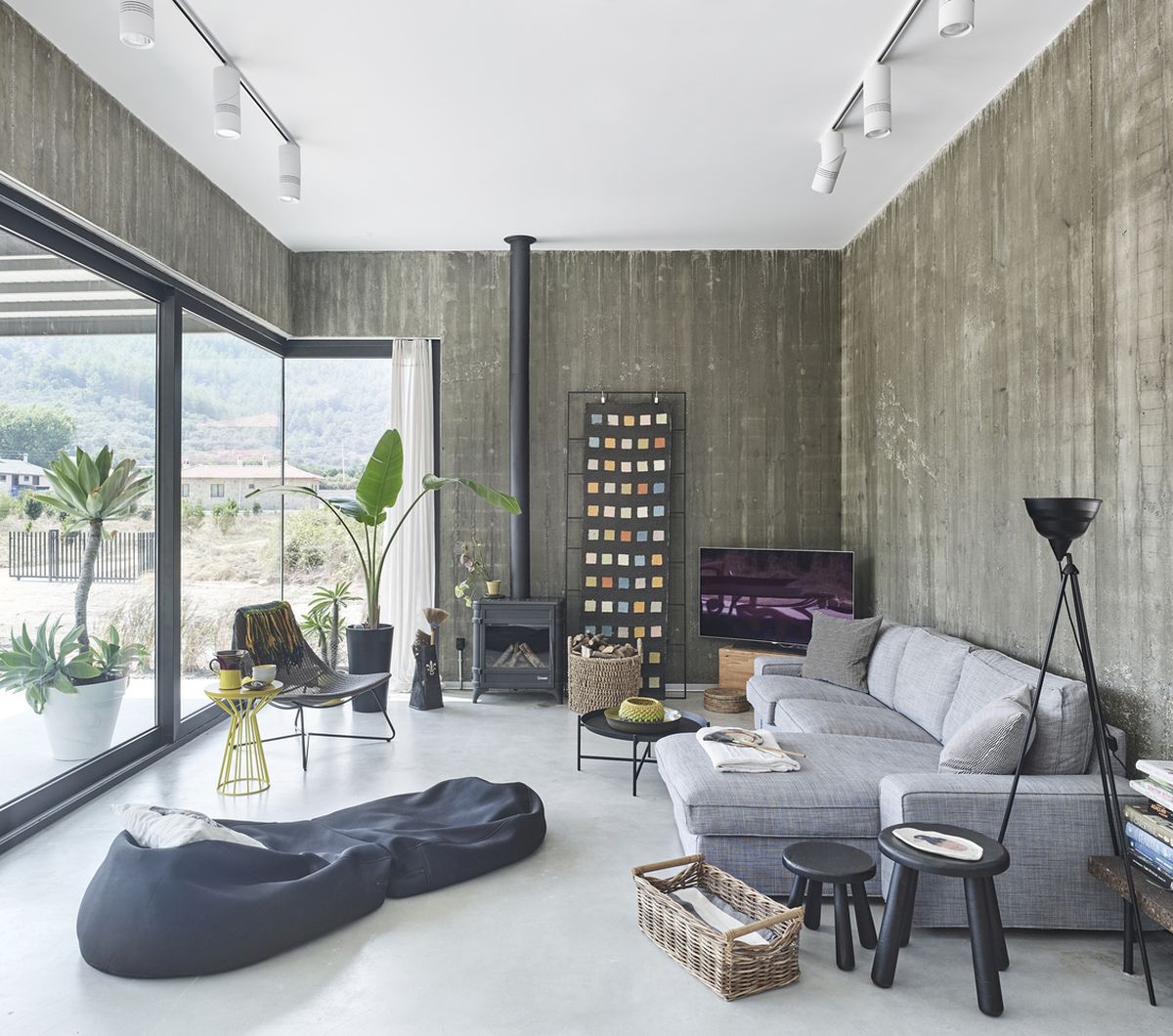 In the living room there's a comfy sectional sofa complemented by various accent tables, poufs and chairs