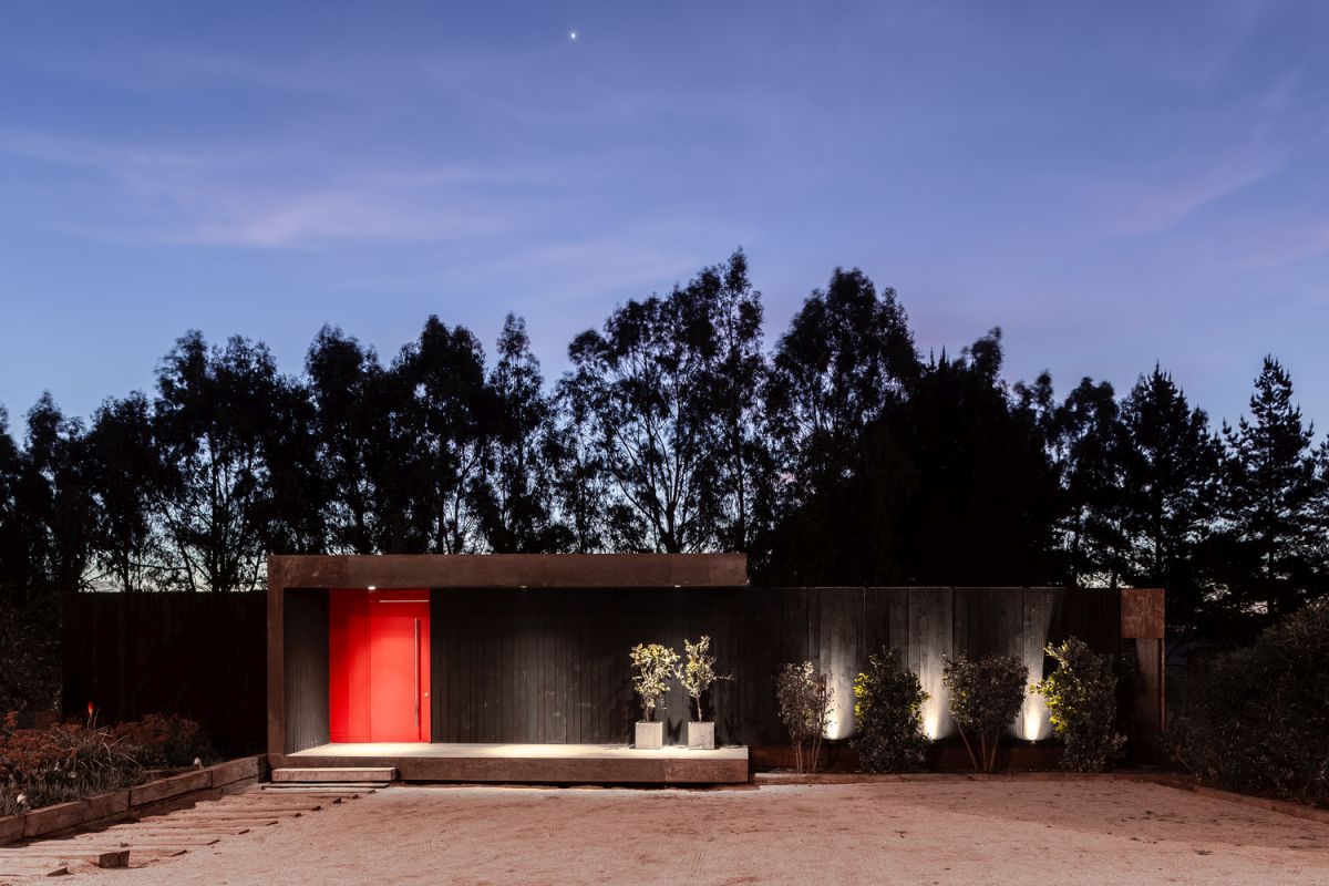 The front facade is all closed and dark with the exception of the bright red front door