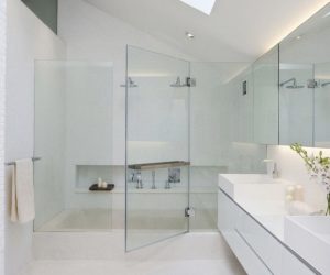 White bathroom with glass shower doors and sky lighting