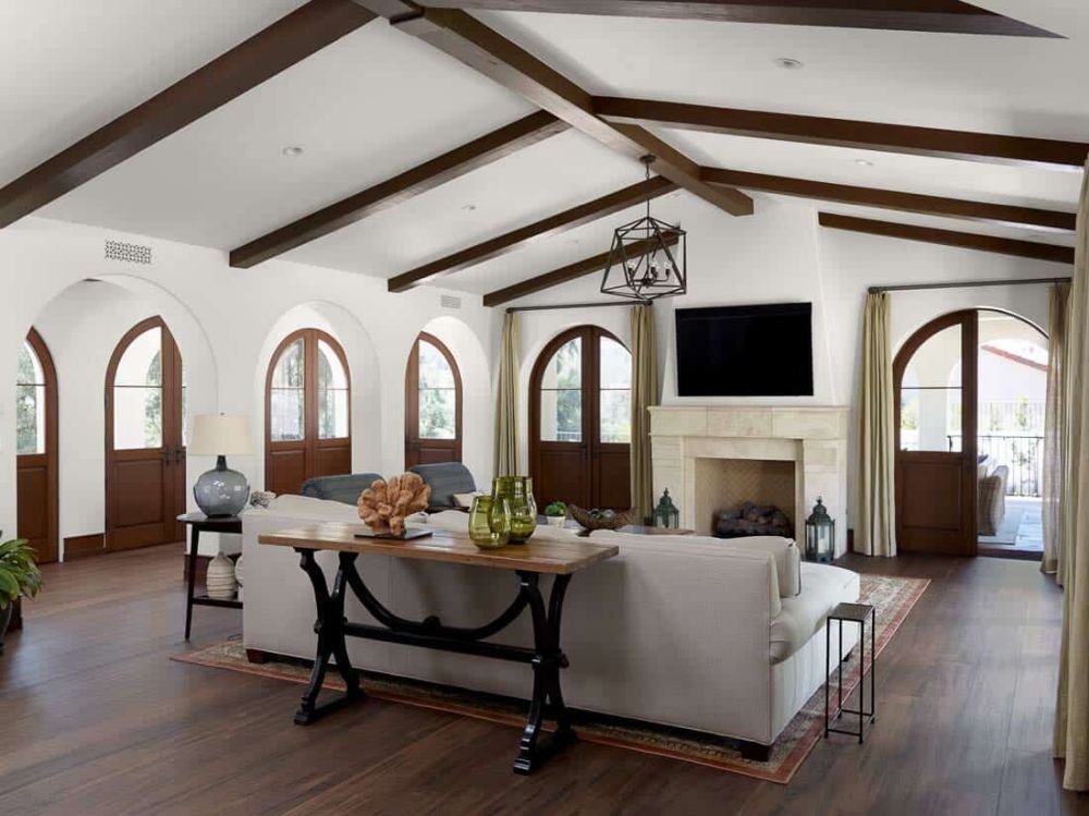 The living room has white walls, a white ceiling and a beautiful dark wood floor