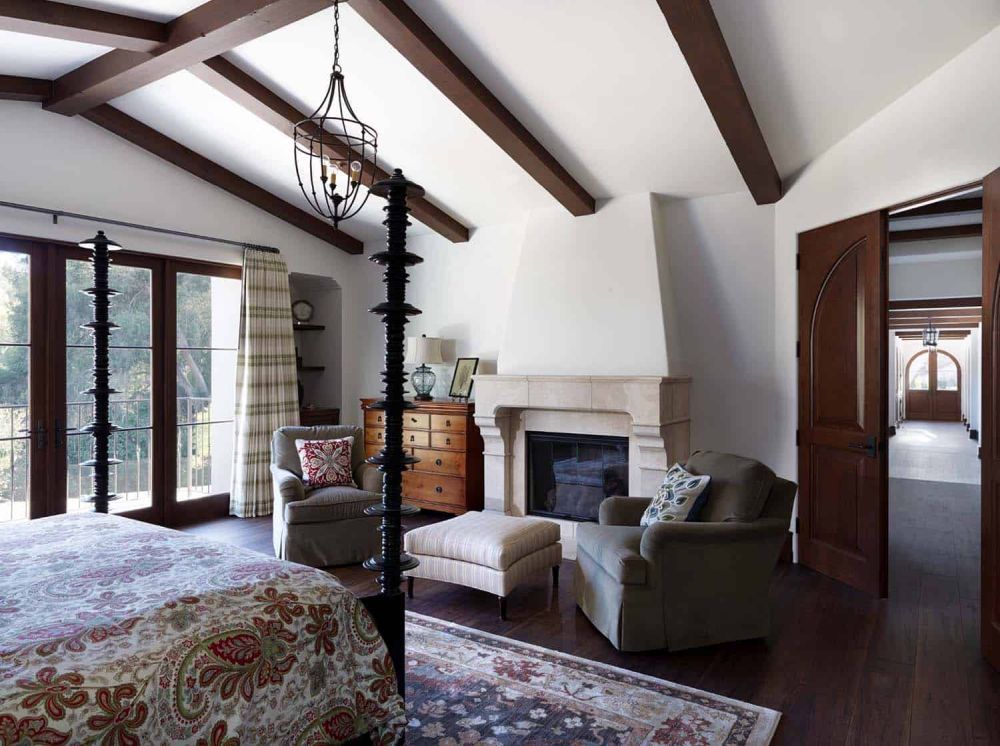 This bedroom also features a fireplace which has a low-key design and complements a sitting area