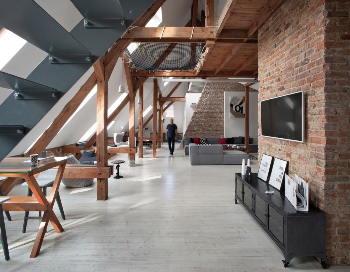 The combination of brick walls, steel stairs and exposed beams gives the apartment a strong industrial vibe
