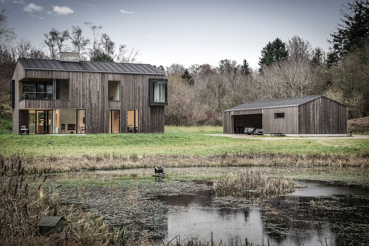 Both the main house and the carport have the same timber-clad exterior and gabled roof