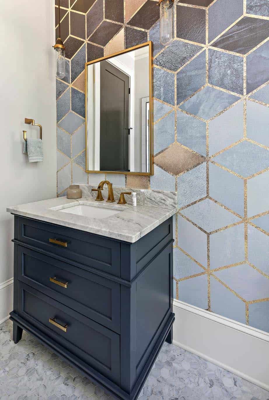 This bathroom has an eye-catching accent wall and a stylish antique brass mirror