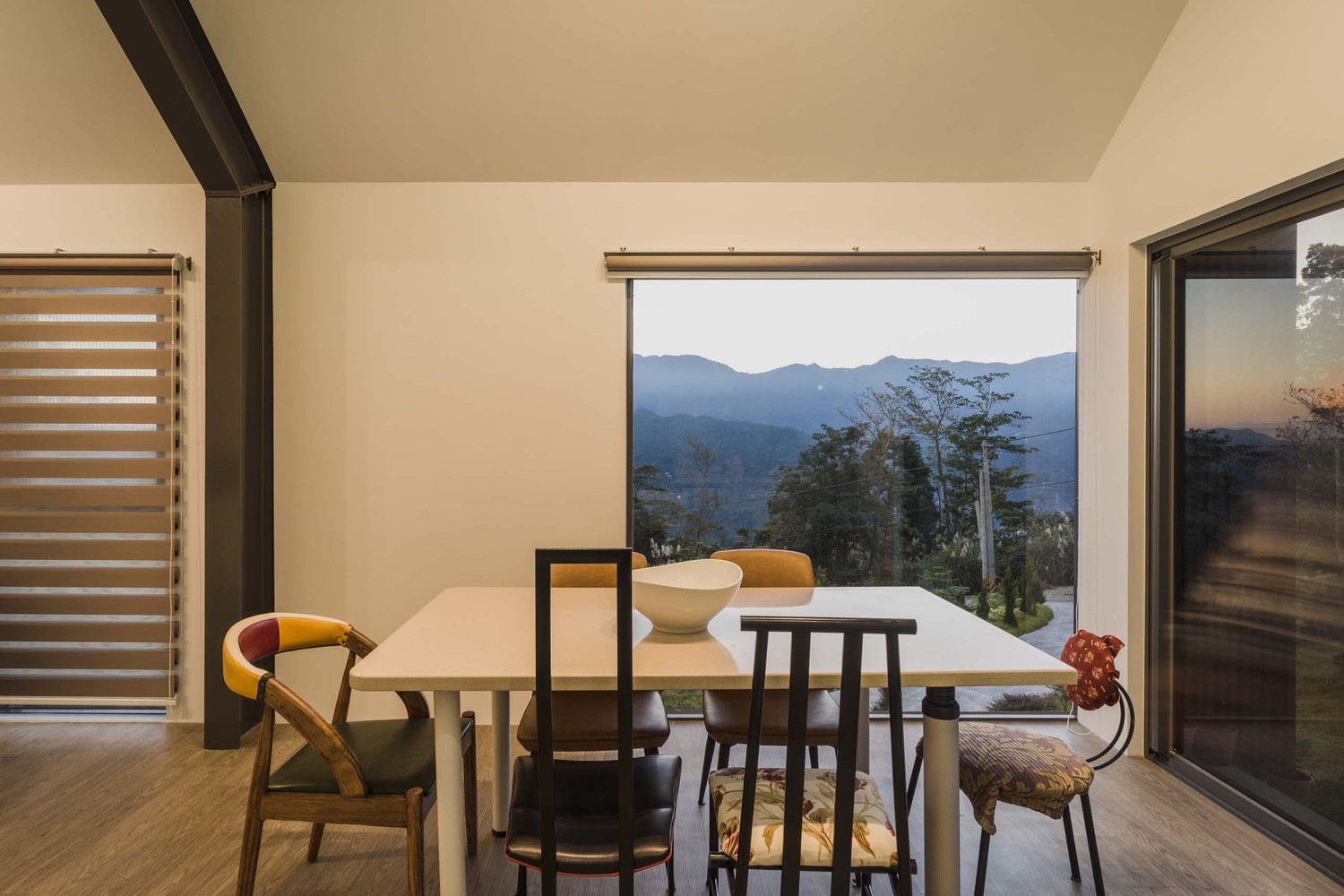 A square-shaped dining table with diverse chairs around it creates a very casual and friendly vibe