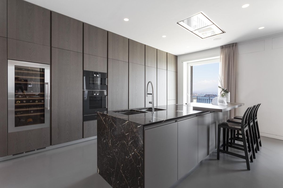 The kitchen is spacious, with a custom storage wall, built-in appliances and an elegant island