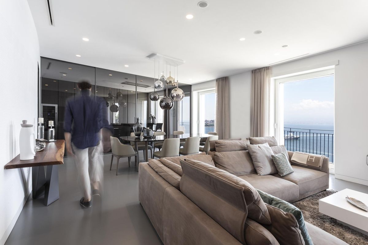 The sectional sofa delineates the living area from the dining space, maintaining its individuality within the open floor plan