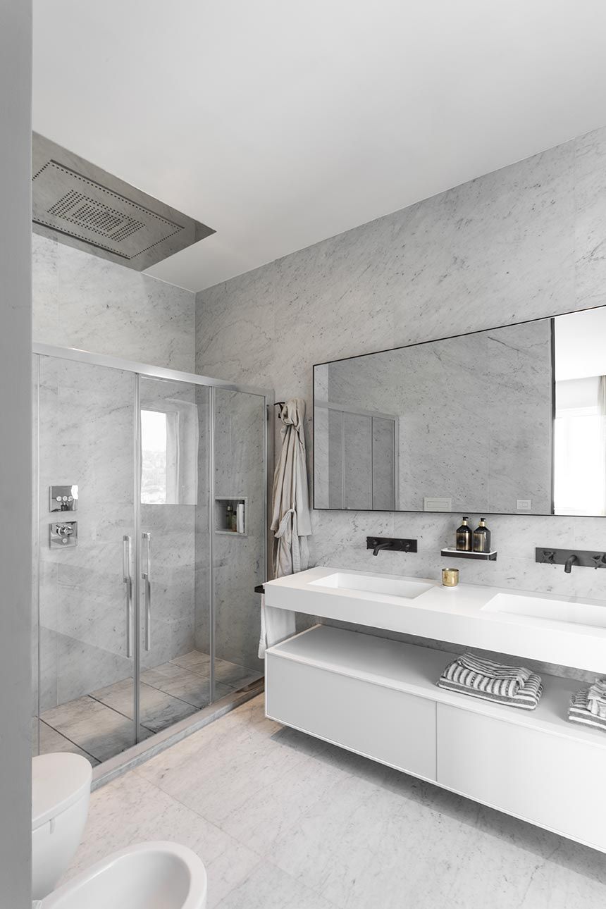The en-suite bathroom is almost entirely covered in white Carrara marble and looks super bright and airy