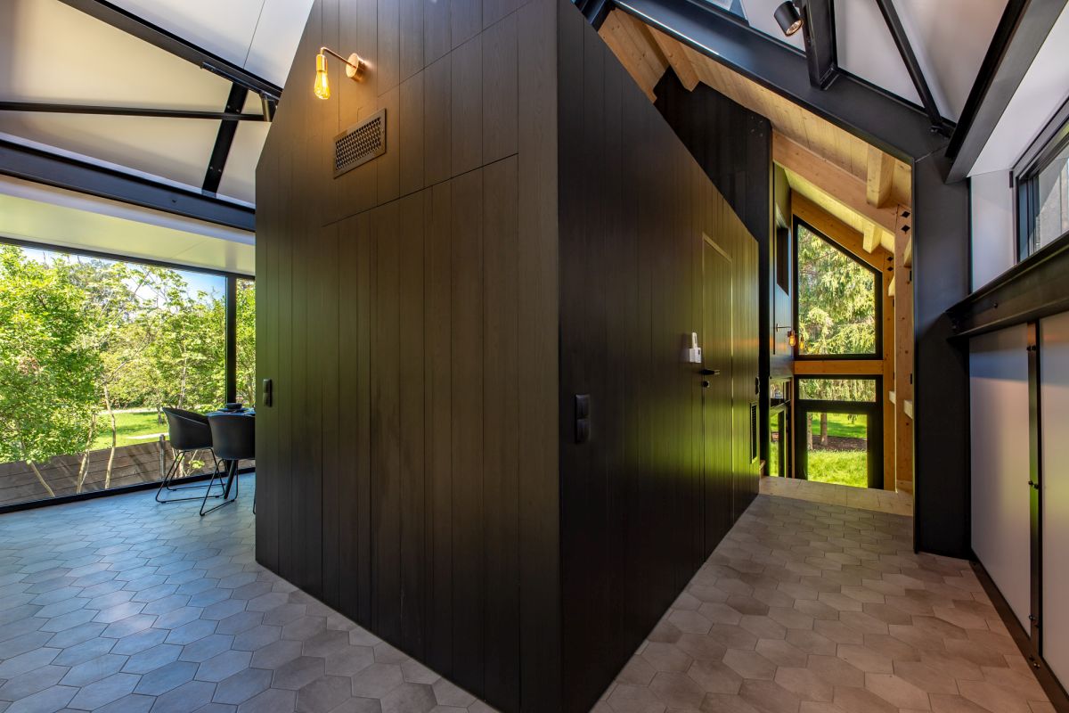 The hexagonal floor tiles ground the upstairs volumes with their warm, earthy color tones
