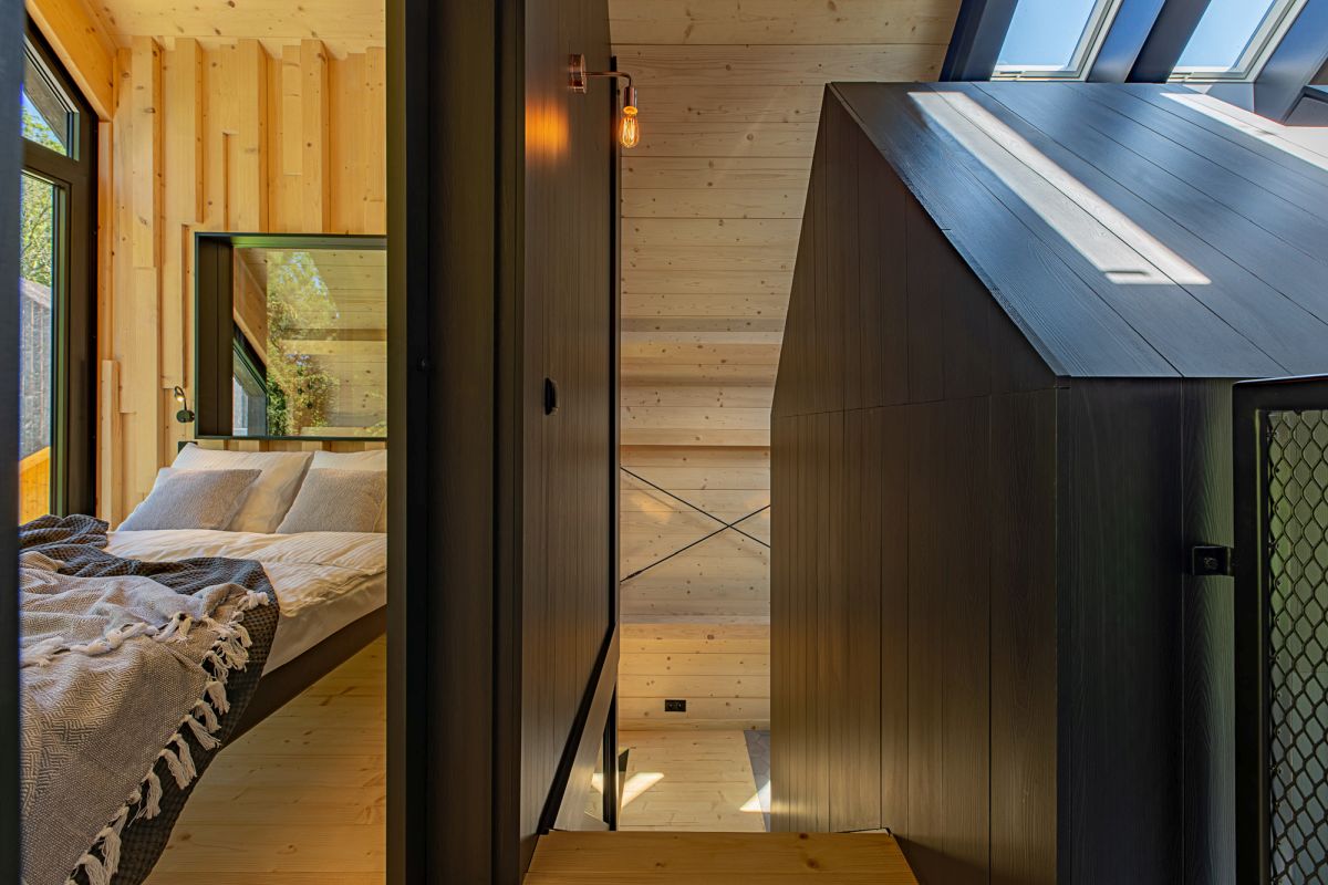 One of the bedrooms is situated upstairs next to the staircase and has a view of the rear deck and the forest beyond