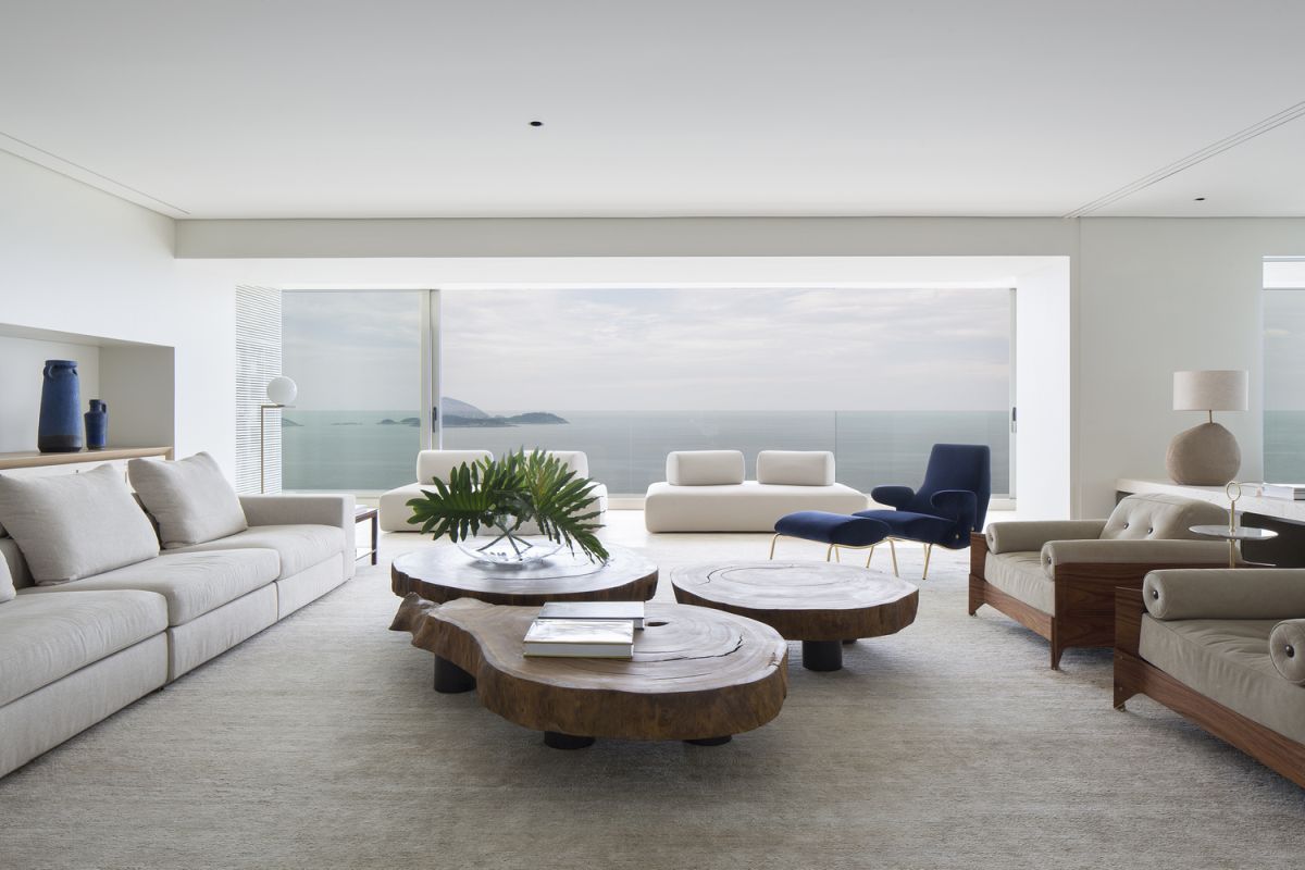 The living room featured three live edge wood tables at the center, surrounded by sofas and armchairs
