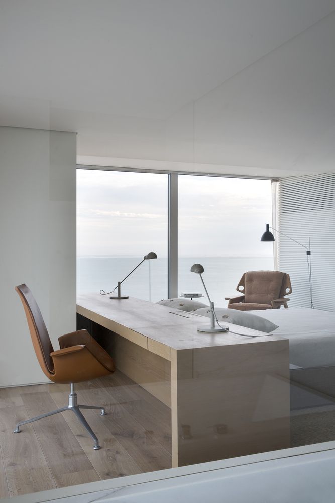 An elegant and very simple desk doubles as a headboard