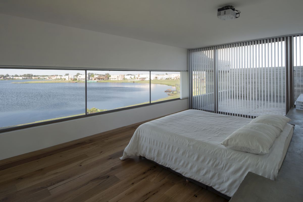 The master bedroom features a set of wide, horizontally narrow windows which overlook the lagoon