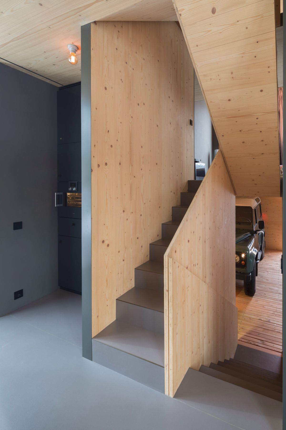 The staircase which connects the floors is very simple and framed by wood panels on either side