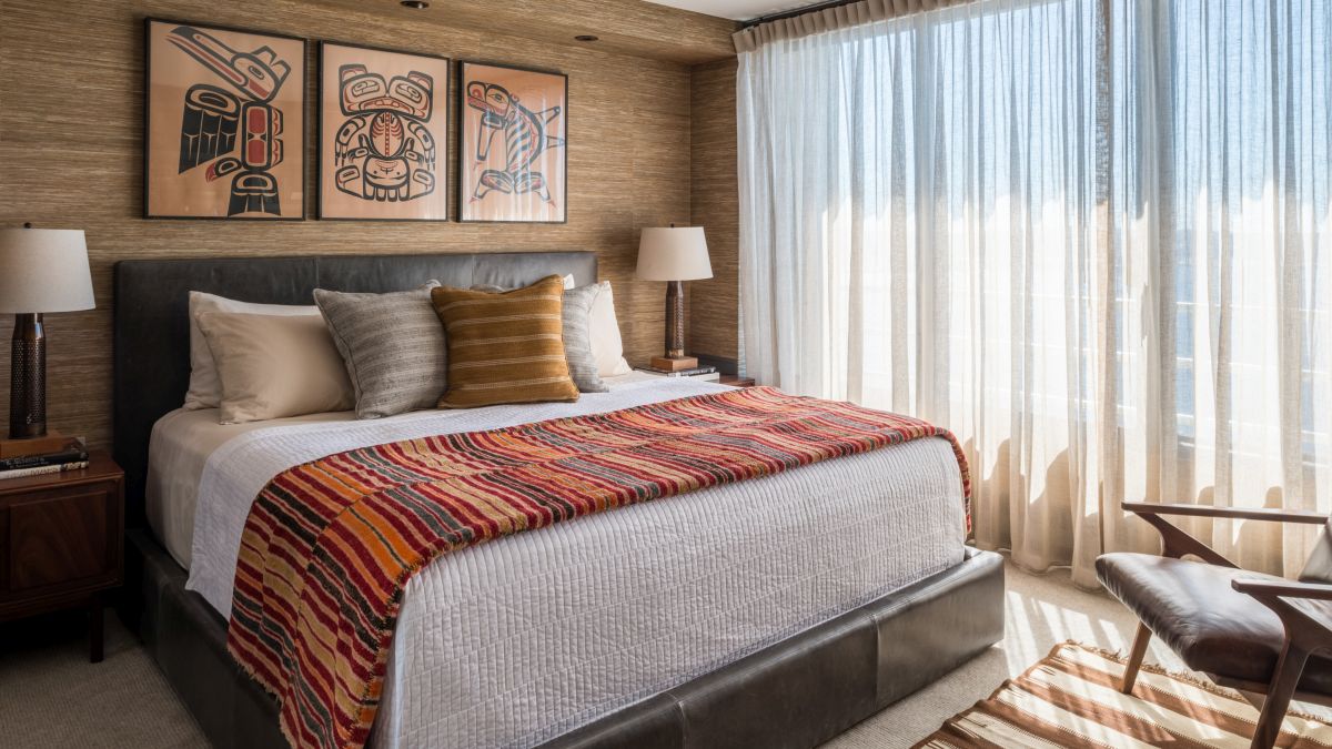 The bedroom features delicate curtains, lots of wood and a variety of textured details
