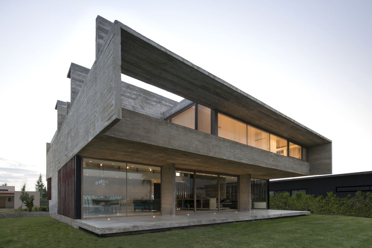 The house is open towards the rear garden, featuring full-height windows downstairs