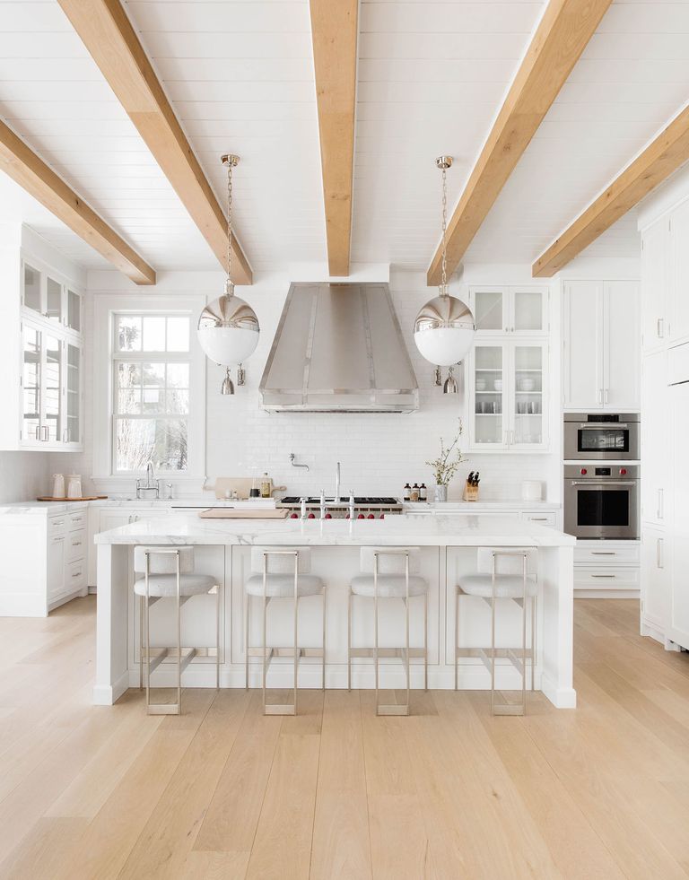all white kitchen with exposed beams and wood floors