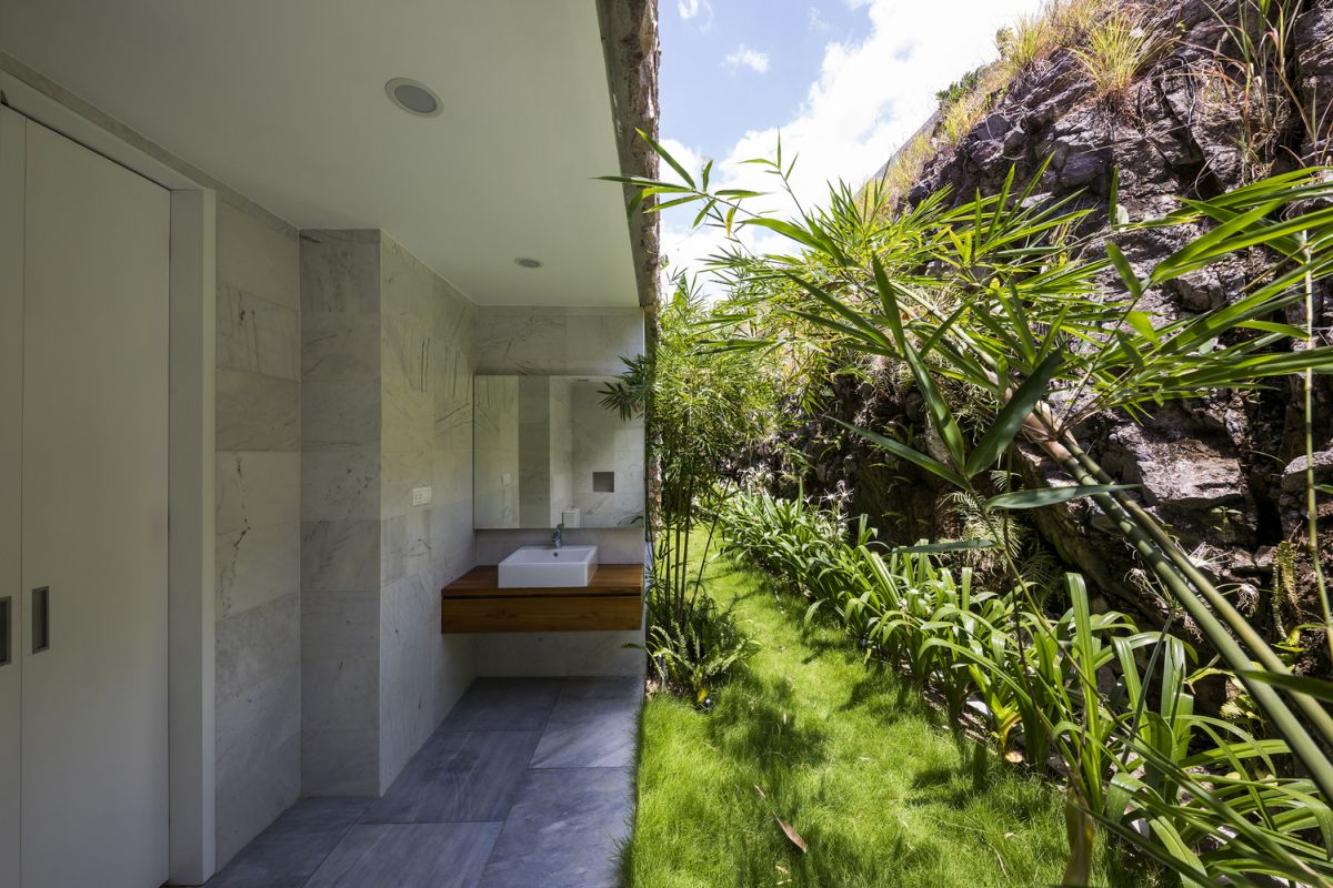 The intermediate level houses a bedroom suite with an outdoor bathroom and private garden