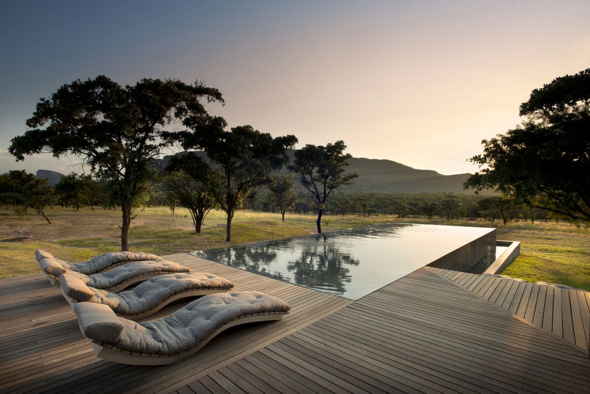 The swimming pool is perfectly level with the deck and reflects the beautiful landscape around it