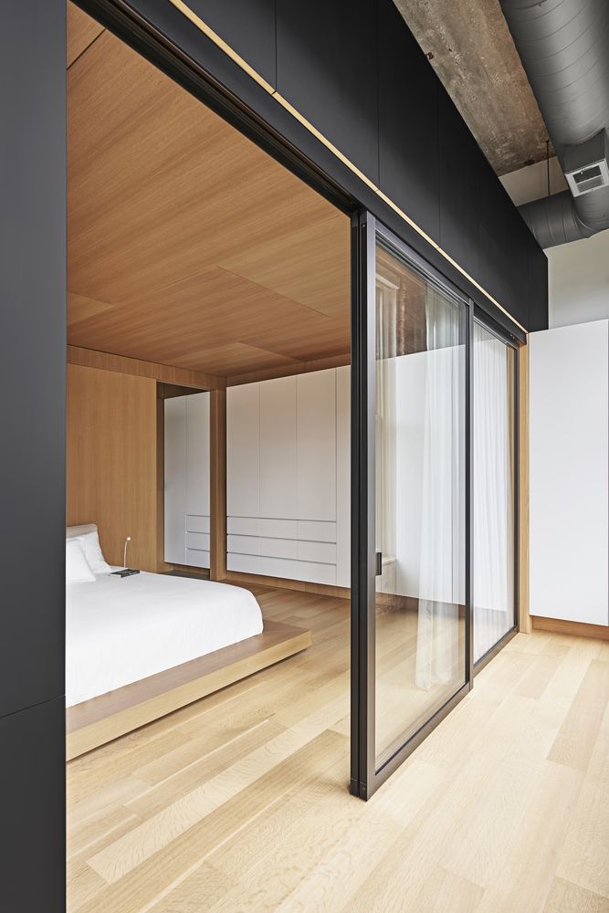 Glass partitions allow light to enter the bedroom and prevent it from feeling small and cluttered