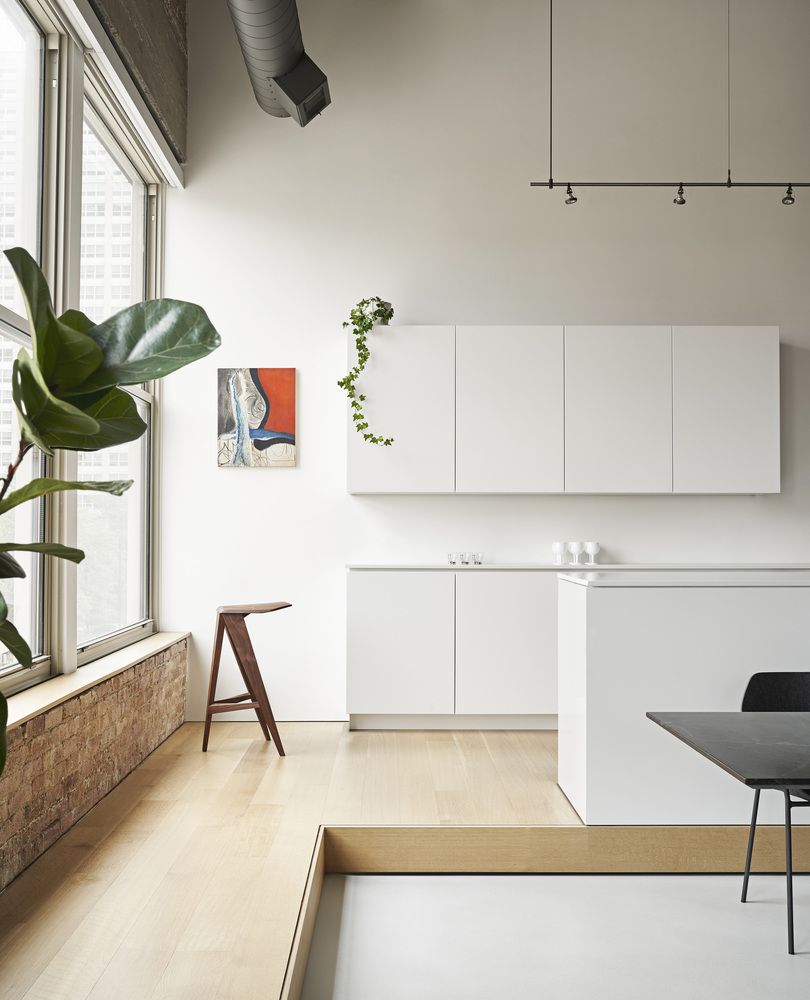 The white kitchen cabinetry blends into the wall creating a very bright and airy decor