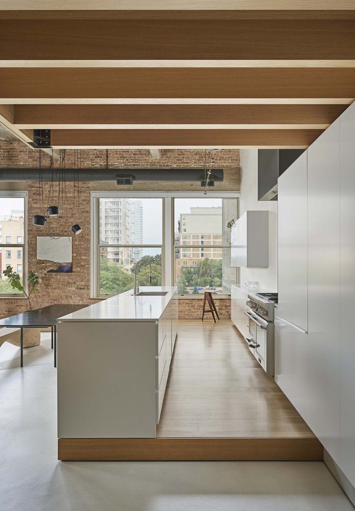 The kitchen is seamlessly integrated into the open plan volume but stands out and has a slightly raised floor