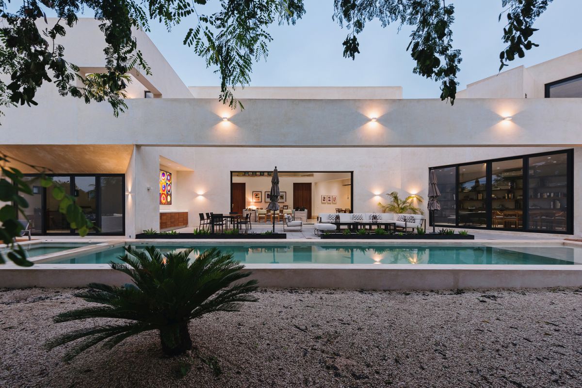the indoor living areas seamlessly open towards a terrace which is turn connects to the swimming pool