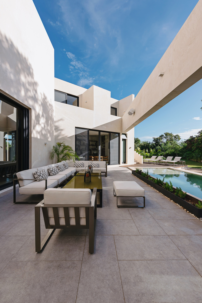 Lush vegetation forms a border on this side of the house, offering privacy