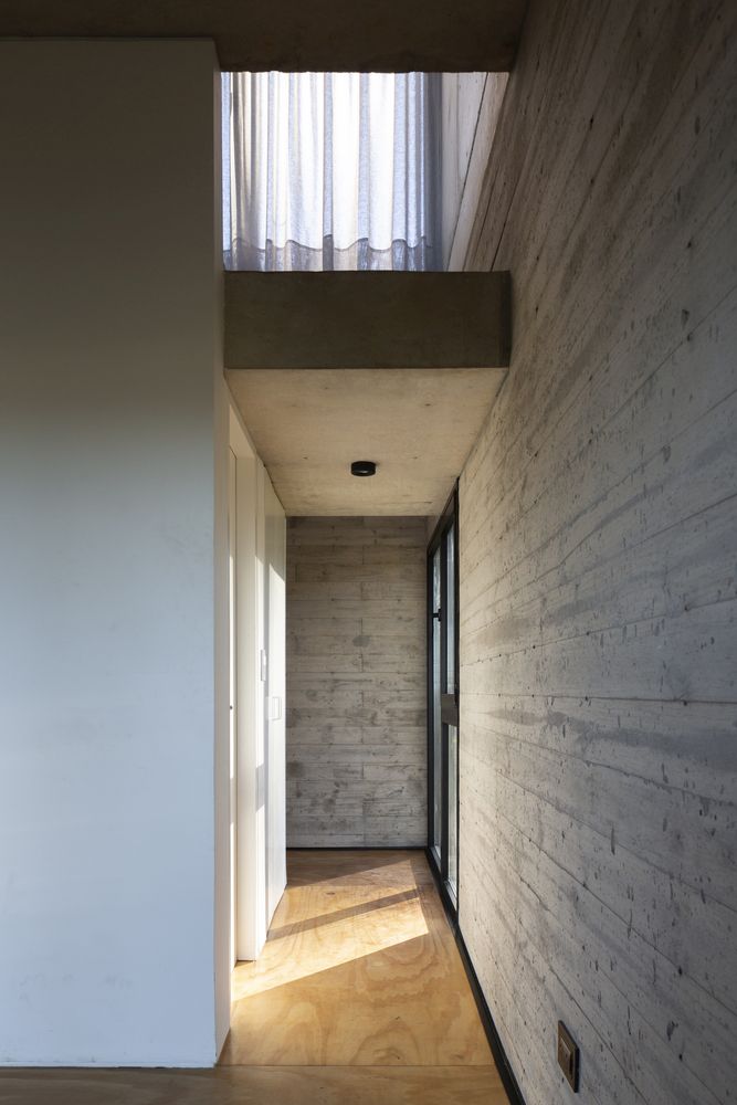 Raw concrete walls are complemented by wooden floors for a balanced and modern look 