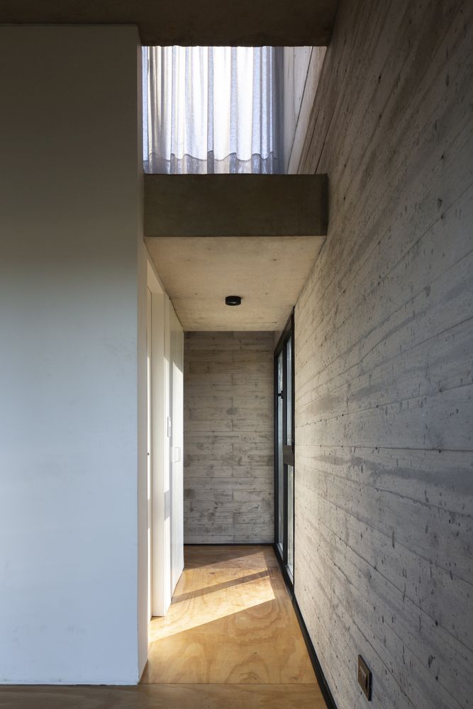 Raw concrete walls are complemented by wooden floors for a balanced and modern look
