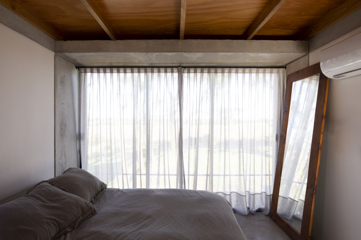 A large framed mirror amplifies the amount of sunlight entering the bedroom while also reflecting the beautiful view