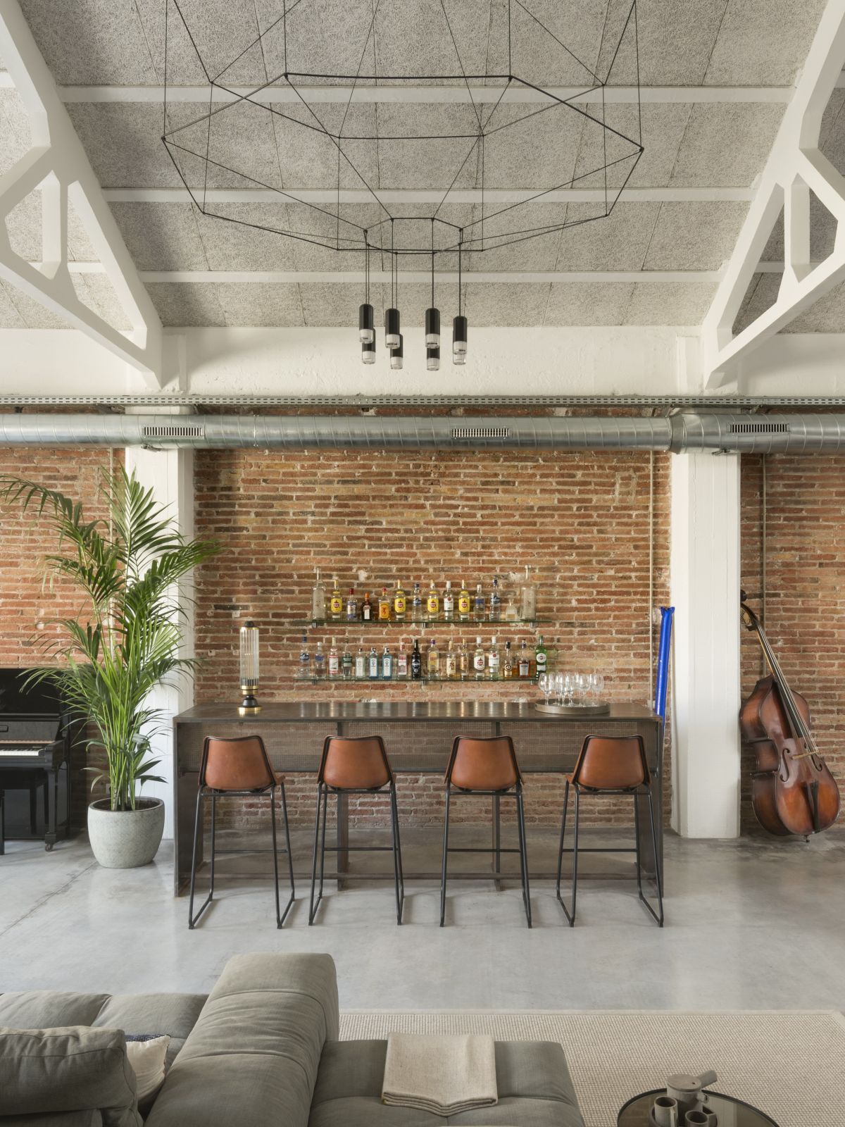 Oversized pendant lamps complement the double-height spaces without looking opulent