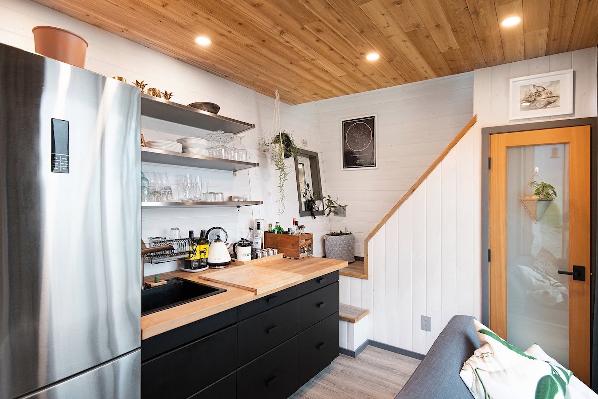 The wood-paneled ceiling and butcher block counter add warmth to the kitchen area