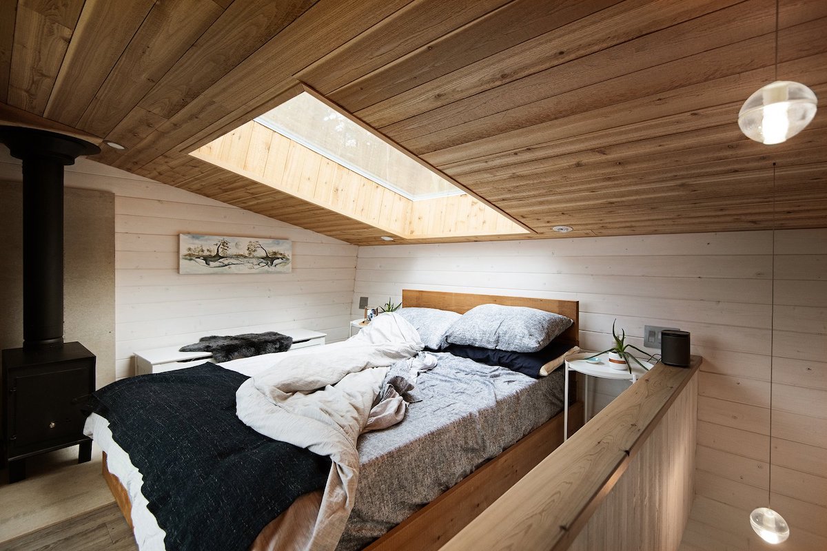The lofted bedroom is small and cozy and has a skylight just above the bed