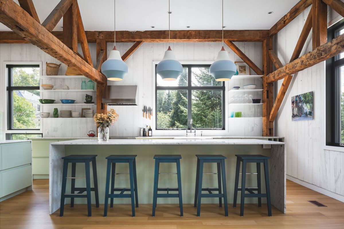 The kitchen is part of the open floor plan and features exposed wooden beams and a view of the garden