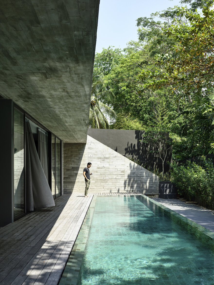 The open area at the back of the house is shielded by concrete walls and lush greenery