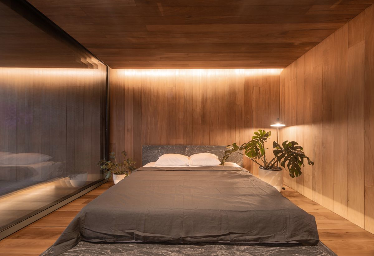 The bedroom is minimalist and features subtle accent lighting and very little furniture