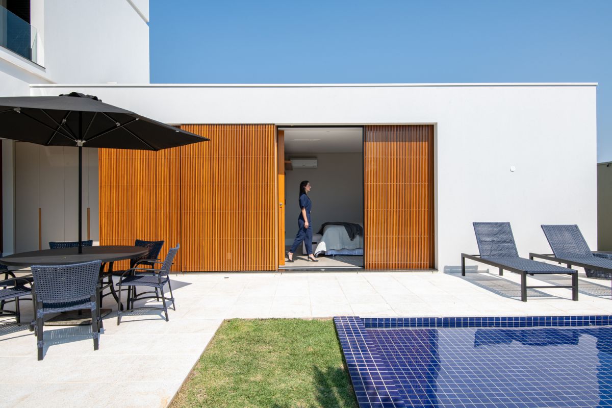 Sliding wooden dividers filter the sunlight and allow the indoor spaces to open up to the garden