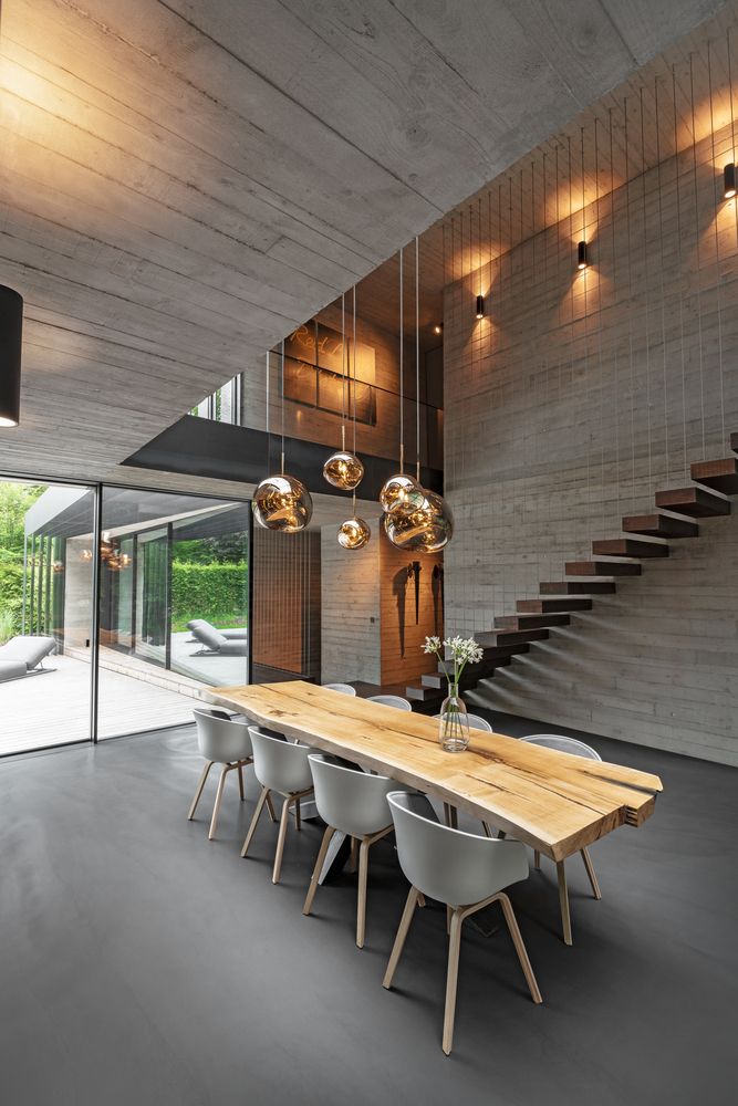 A minimalist staircase appears to be floating against the dining room wall, connecting the two floors