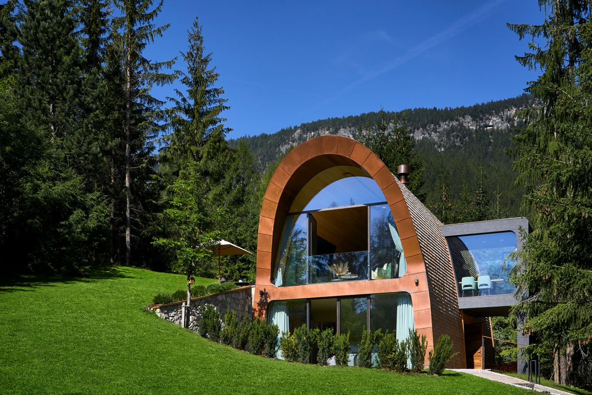 The chalet disappears partially into the hillside, forming a small courtyard around it