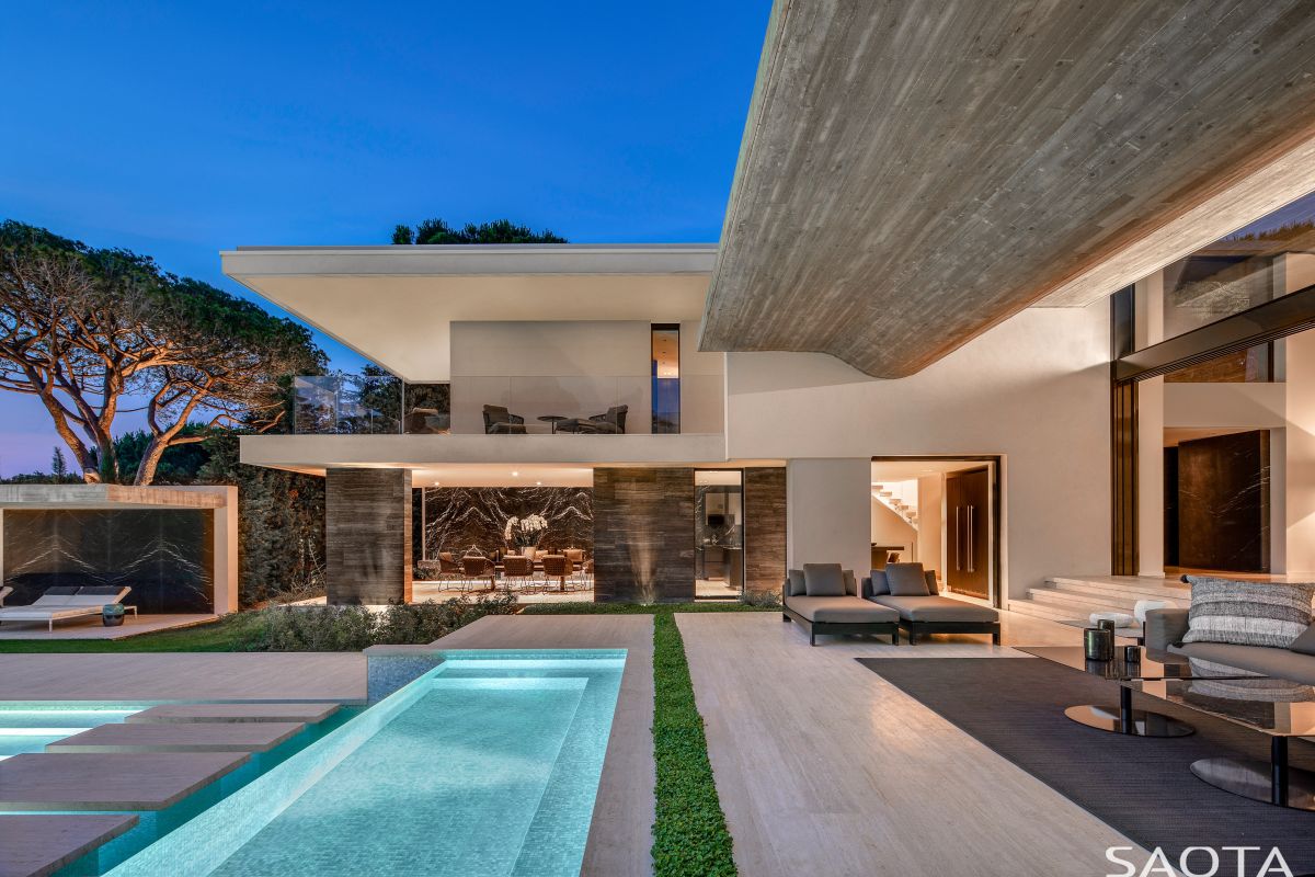 The house is structured into two wings connected by a central volume with a floating wooden roof