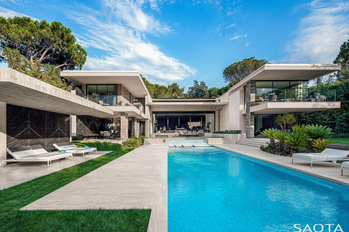The house takes advantage of the elongated site, extending outside and forming generous outdoor volumes