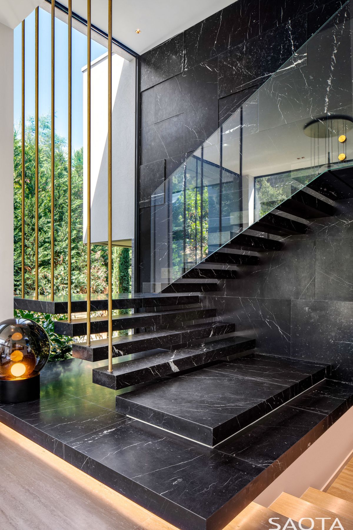 A staircase connects the master bedroom suite to a private lounge area with a double height ceiling