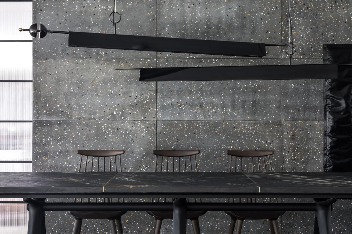 The dining area is lit by two minimalis and linear pendant lights with a black finish