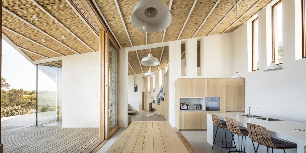 The roof extends and forms an overhang, creating a transitional space between the indoor and the outdoor