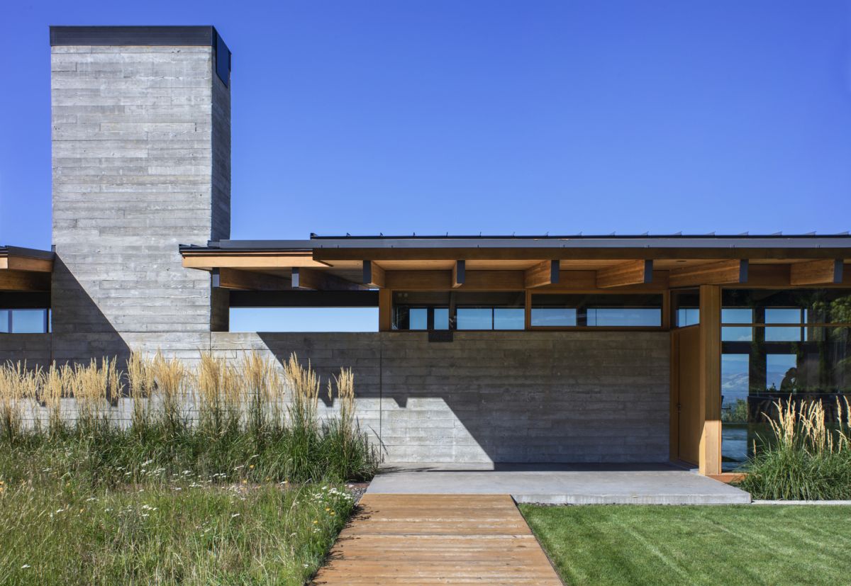 The concrete wall also incorporates a tall chimney for the central fireplace